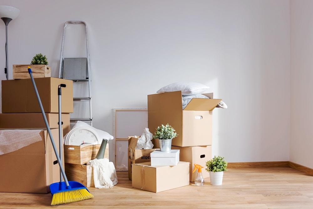 a broom in front of a pile of boxes.